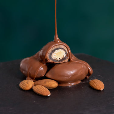 Datteln mit Vollmilchschokolade auf edlem Präsentationsuntergrund